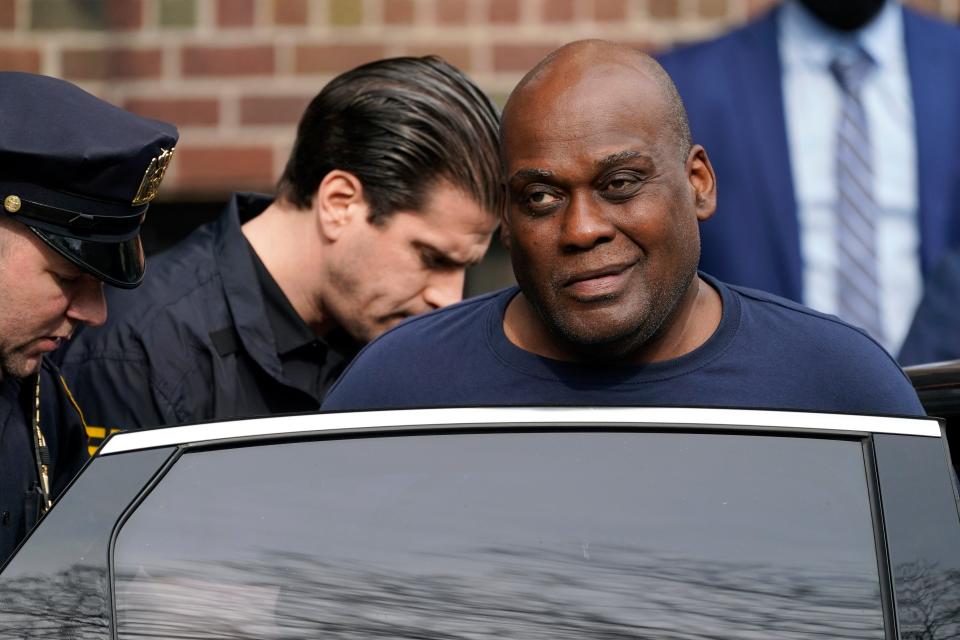 Law enforcement officials lead Brooklyn subway shooting suspect Frank R. James, 62, right, away from a police station and into a vehicle on April 13 in New York.