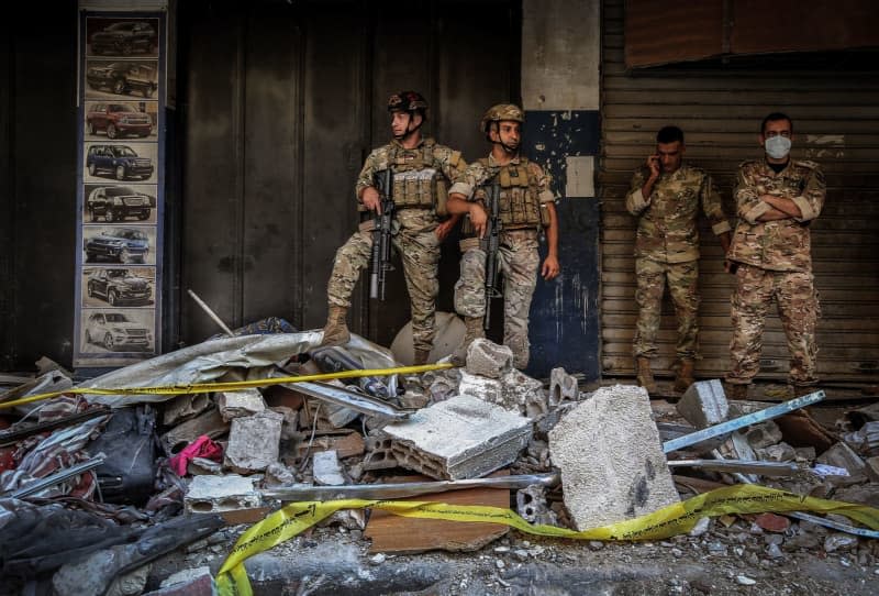 Lebanese army soldiers secure the scene of an Israeli airstrike in the southern suburb of Beirut. Six people were killed and 15 others wounded in the strike, which targeted Hezbollah's missile chief, the Israeli military said, according to Lebanon's Health Ministry. Marwan Naamani/dpa