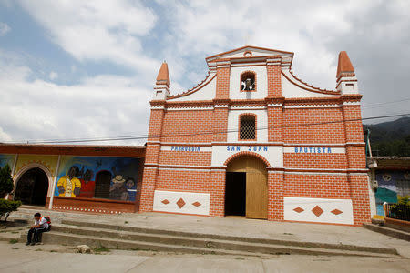 A boy sits next to the main church in Toribio, Cauca, Colombia, February 9, 2016. REUTERS/Jaime Saldarriaga