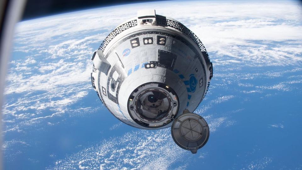 a cone-shaped spacecraft with hatch open flying in space. behind is the earth