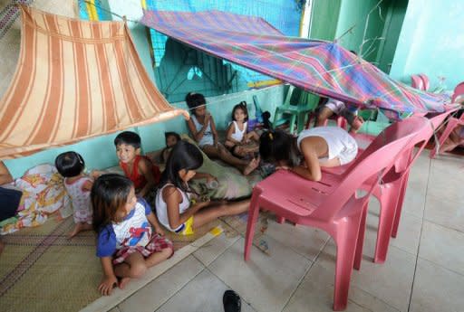 Children play inside an evacuation centre in Navotas City, suburban Manila on August 2, 2012, after heavy rains and strong winds were brought about by Typhoon Saola