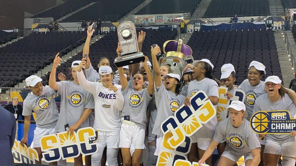 The James Madison women's basketball team celebrates after capturing the Sun Belt Conference championship with an 81-51 victory over Texas State from the Pensacola Bay Center.