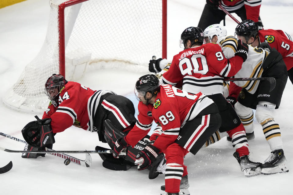 Chicago Blackhawks goaltender Petr Mrazek makes a stick save on a shot by Boston Bruins' Charlie McAvoy as Andreas Athanasiou (89) also defends during the second period of an NHL hockey game Tuesday, Oct. 24, 2023, in Chicago. (AP Photo/Charles Rex Arbogast)