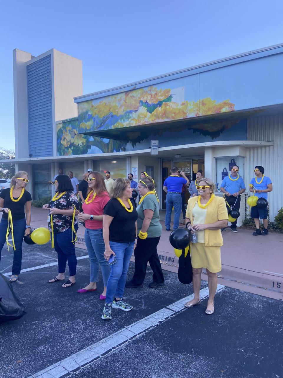 City of Stuart employees gather opposite city hall near the rail tracks around 8 a.m. Friday Sept. 22, 2023 donning yellow sunglasses, garlands, and black and yellow balloons, waiting to cheer the Brightline train go by.