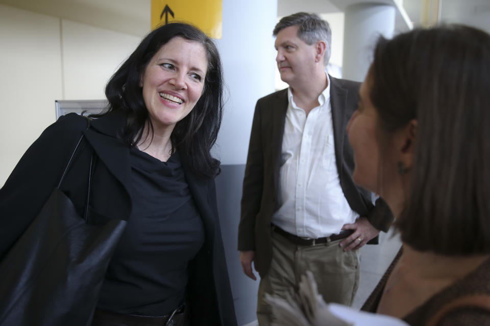 Laura Poitras smiles after arriving at John F. Kennedy International Airport after arriving at John F. Kennedy International Airport on Friday, April 11, 2014 in New York. Poitras and Glenn Greenwald share a George Polk Award for national security reporting with The Guardian's Ewen MacAskill and Barton Gellman, who has led The Washington Post's reporting on the NSA documents. (AP Photo/John Minchillo)