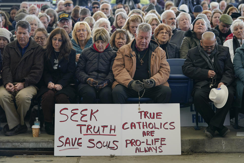 FILE - People play the Rosary during a rally outside of the Baltimore hotel where the United States Conference of Catholic Bishops are holding its Fall General Assembly meeting in Baltimore, Nov. 16, 2021. The city of Baltimore has agreed to pay $275,000 toward the legal fees of a far-right Catholic media group to settle a lawsuit over the city's unsuccessful attempt to block a rally in 2021. (AP Photo/Julio Cortez, File)