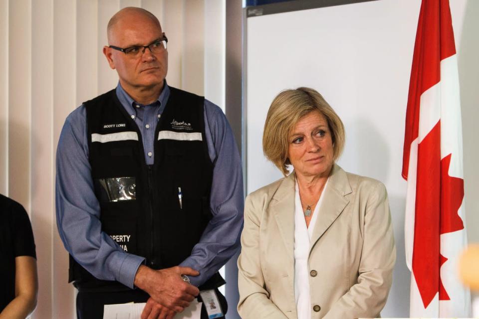 Alberta Emergency Management Agency executive director of operations Scott Long, left, and Alberta Premier Rachel Notley, right, listen during an update on the wildfire situation currently underway in and around Fort McMurray at the Provincial Operations Centre in Edmonton on Wednesday, May 4, 2016. THE CANADIAN PRESS/Codie McLachlan