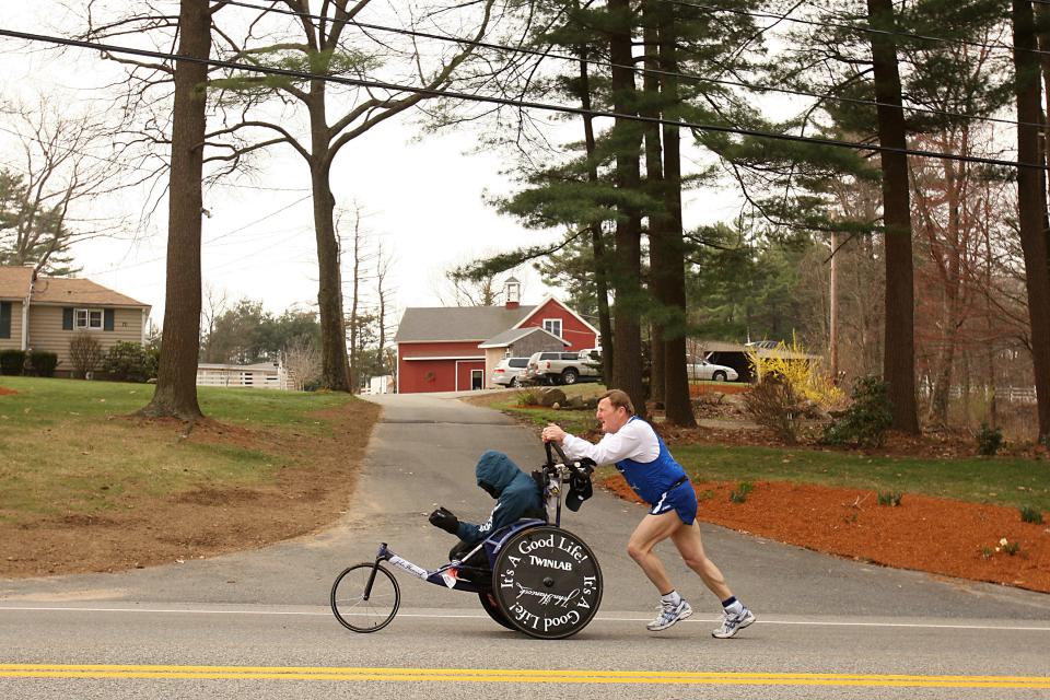 HOPKINTON, MA - APRIL 21:  Dick Hoyt pushes Rick Hoyt as they compete in the 2008 Boston Marathon on April 21,2008 in Hopkinton, Massachusetts. Nearly 25,000 people participated in the race. (Photo by Elsa/Getty Images)