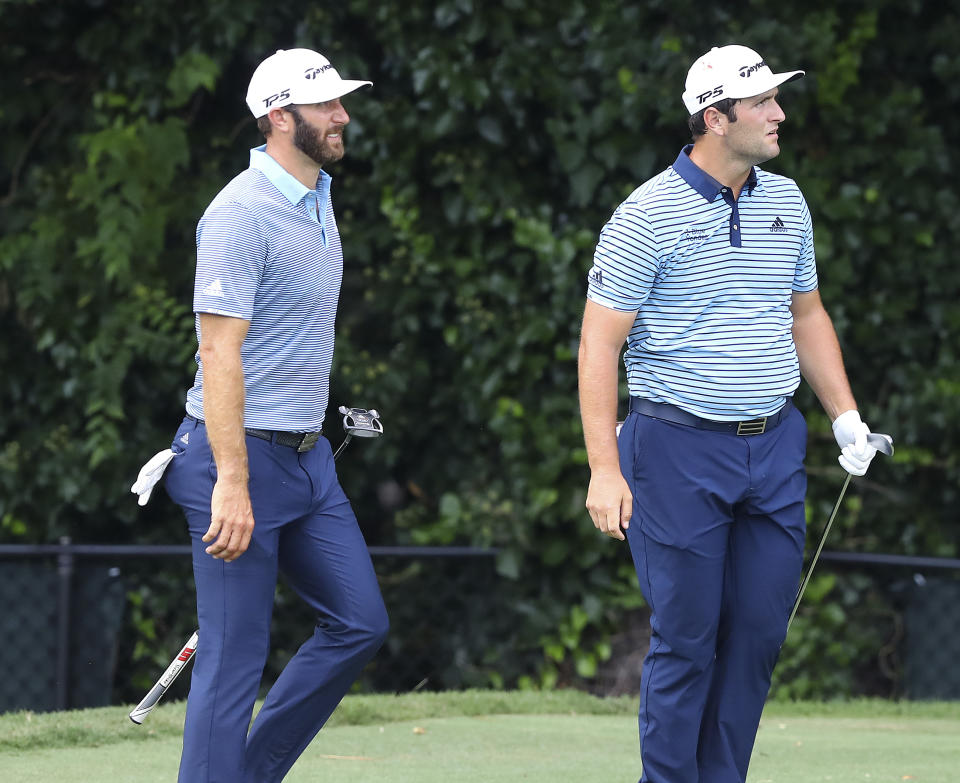 Dustin Johnson, left, and Jon Rahm watch Rahm's tee shot to the par-3 second green during their first round of the Tour Championship golf tournament at East Lake Golf Club on Friday, Sept. 4, 2020, in Atlanta. (Curtis Compton/Atlanta Journal-Constitution via AP)