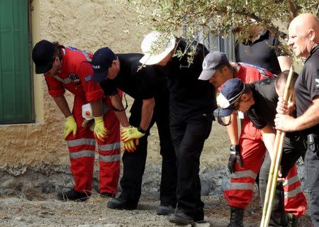 South Yorkshire police officers and members of the Greek rescue service (in red uniforms) investigate the ground before commencing excavating a site for Ben Needham, a 21 month old British toddler who went missing in 1991, on the island of Kos, Greece, September 26, 2016. REUTERS/Vassilis Triandafyllou