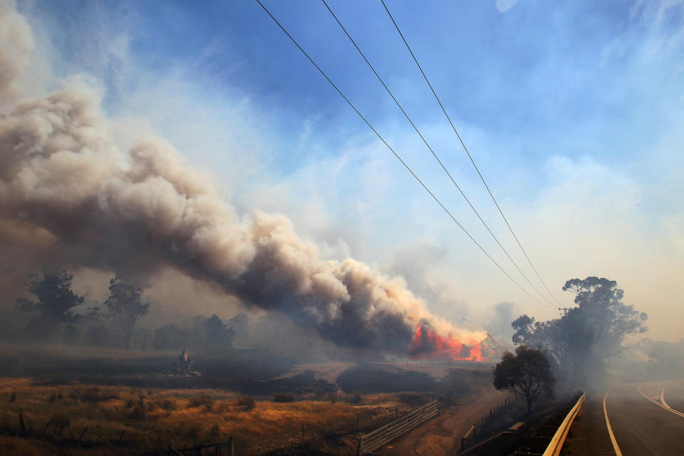 Smoke rises from a burning property in Dunalley, Tasmania (Richard Jupe/Newspix/Rex Features)