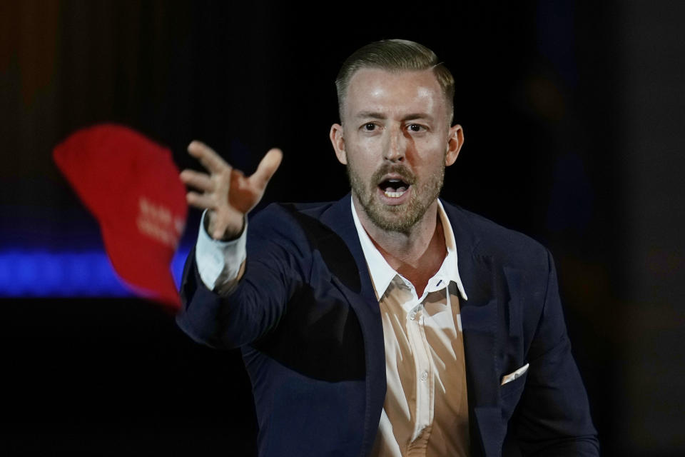 FILE - Ryan Walters, Republican candidate for Oklahoma superintendent of public instruction, tosses out "Make America Great Again" ball caps at a rally Nov. 1, 2022, in Oklahoma City. When Oklahoma's newly elected Republican head of public schools campaigned for the job last fall, he ran on a platform of fighting "woke ideology" in public schools, banning certain books from school libraries, empowering parents with school choice and getting rid of "radical leftists" he claims were indoctrinating children in classrooms across the state. (AP Photo/Sue Ogrocki, File)