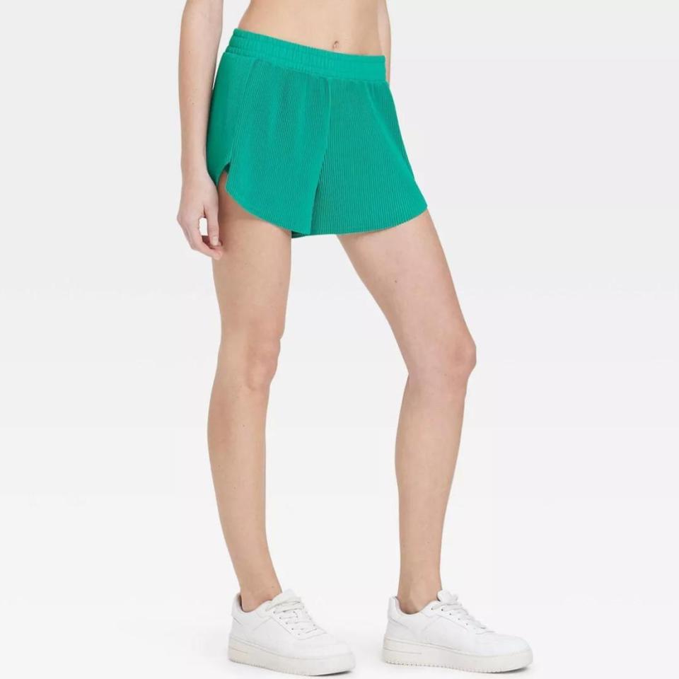 model wearing green ribbed shorts with white sneakers