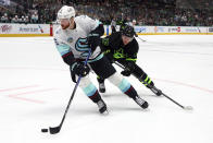 Seattle Kraken defenseman Adam Larsson (6) gets the puck from Dallas Stars center Radek Faksa (12) in the first period of an NHL hockey game on Saturday, April 13, 2024, in Dallas. (AP Photo/Richard W. Rodriguez)