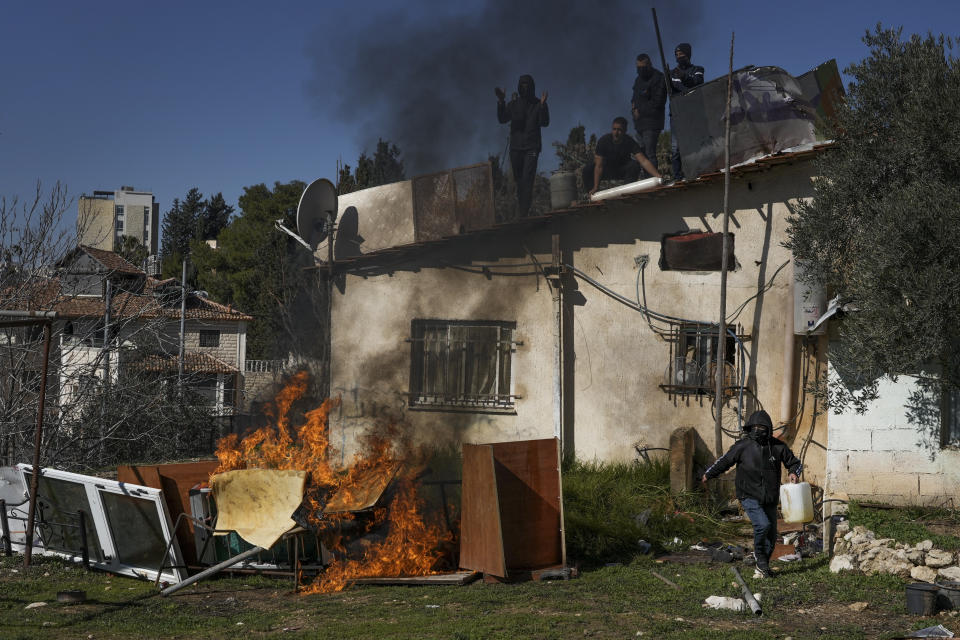 FILE - Palestinian men stand on the roof of a house as Israeli police prepare to evict a family, in the flashpoint east Jerusalem neighborhood of Sheikh Jarrah, Jan. 17, 2022. Israel’s Supreme Court ruled Tuesday, March 1, 2022, that Palestinian families slated for eviction from their east Jerusalem homes can remain for the time being. The families are among dozens in Jerusalem who are threatened with eviction by Jewish settler organizations (AP Photo/Mahmoud Illean, File)