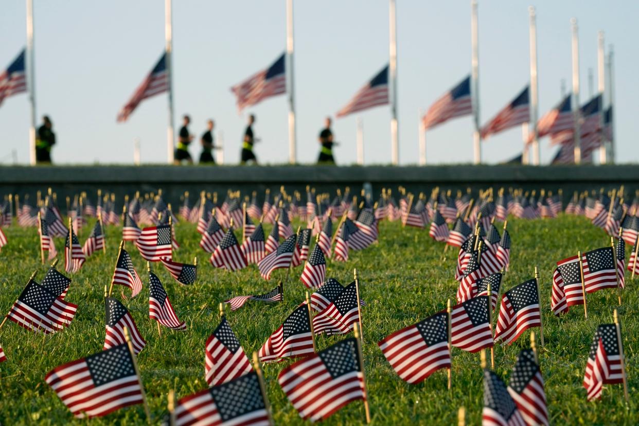 Activists from the COVID Memorial Project mark the deaths of 200,000 lives lost in the U.S. to COVID-19 after placing thousands of small American flags on the grounds of the National Mall in Washington, D.C. on Tuesday, Sept. 22, 2020.