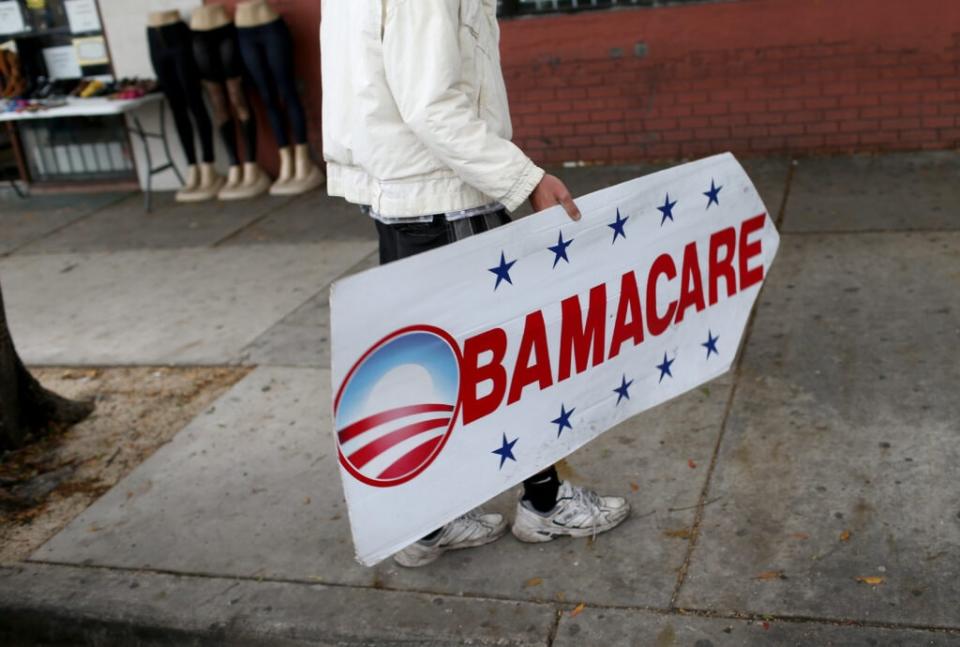 Pedro Rojas holds a sign directing people to an insurance company where they can sign up for the Affordable Care Act, also known as Obamacare, before the February 15th deadline on February 5, 2015 in Miami, Florida. (Photo by Joe Raedle/Getty Images)