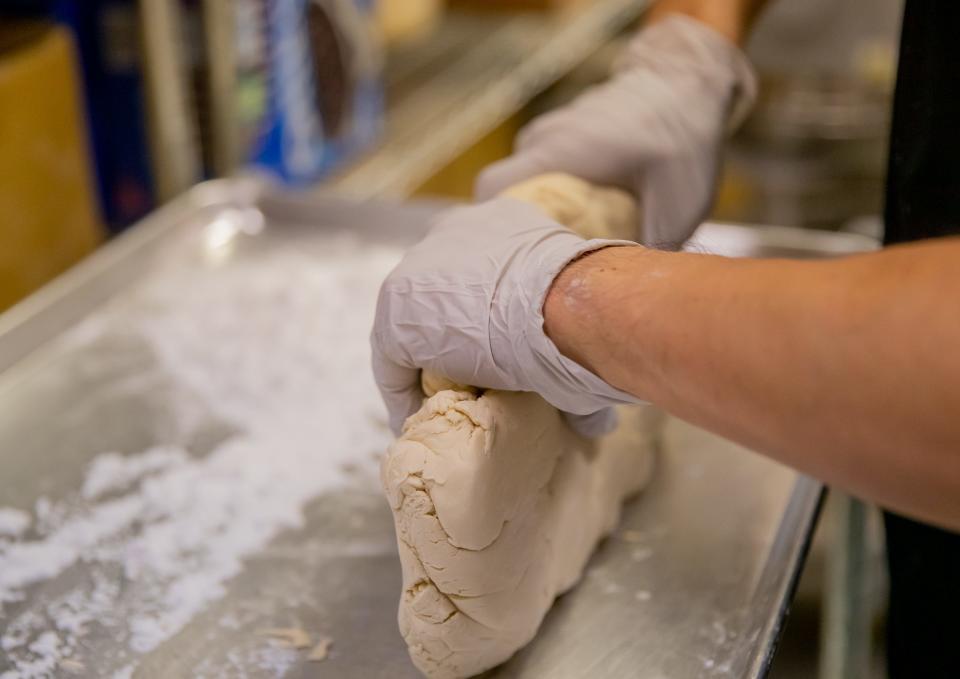 AB Wang kneads dough into a rectangular shape as he prepares to make tapioca pearls inside his shop, Mochi Fresh, in Tempe on May 12, 2023.