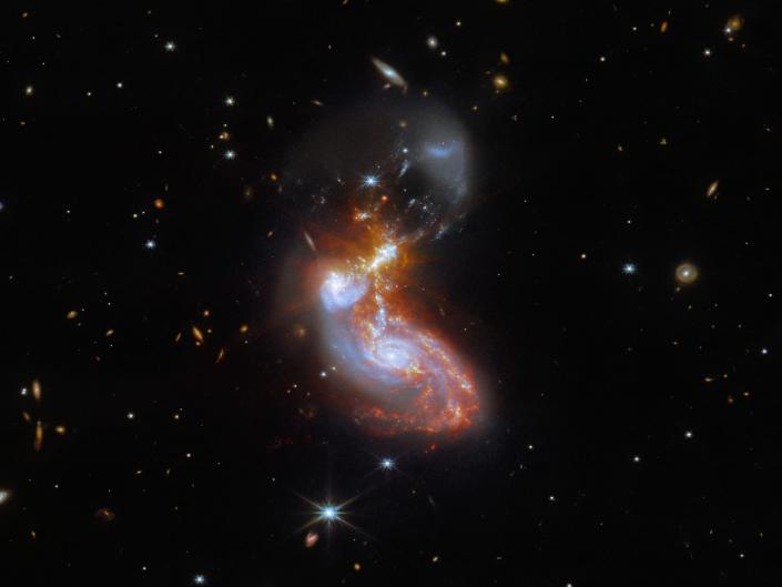 Two colorful galaxies merging in space