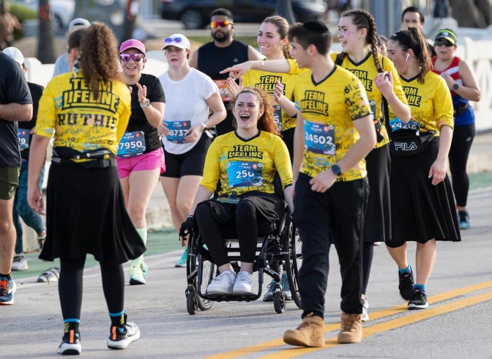 Participantes se animan unos a otros mientras recorren el Viaducto Venetian en Miami Beach, durante el Maratón y Medio Maratón Life Time de Miami, el domingo 29 de enero de 2023.