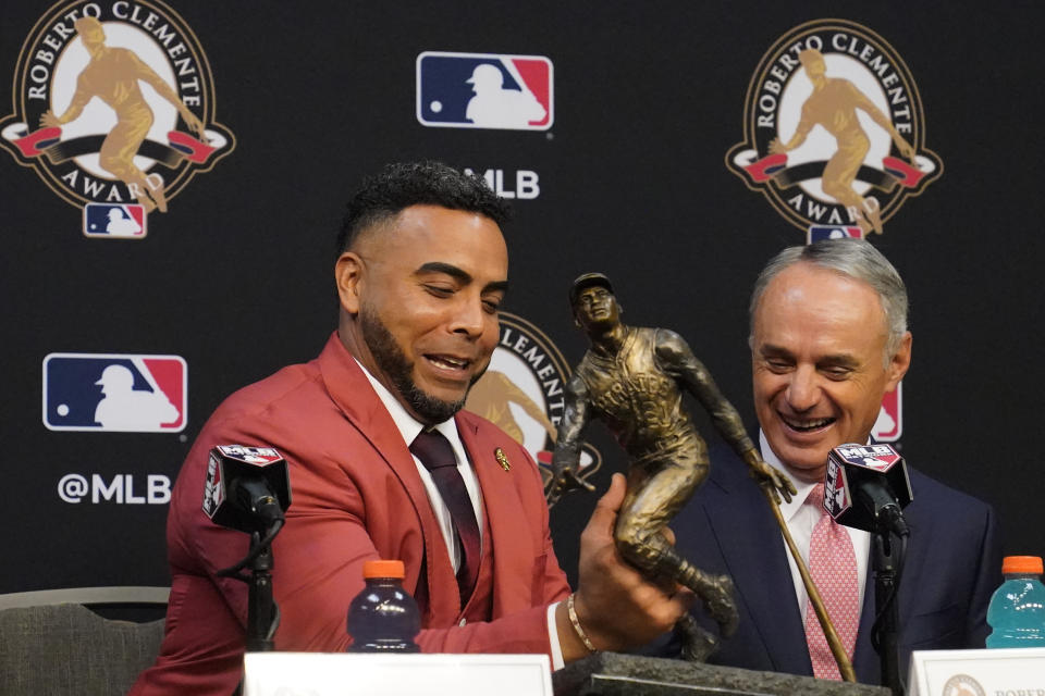 Nelson Cruz, 2021 Roberto Clemente Award winner and Robert D. Manfred, Jr.,MLB Commissioner, look at the trophy during a news conference before Game 2 of baseball's World Series between the Houston Astros and the Atlanta Braves Wednesday, Oct. 27, 2021, in Houston.(AP Photo/Sue Ogrocki)