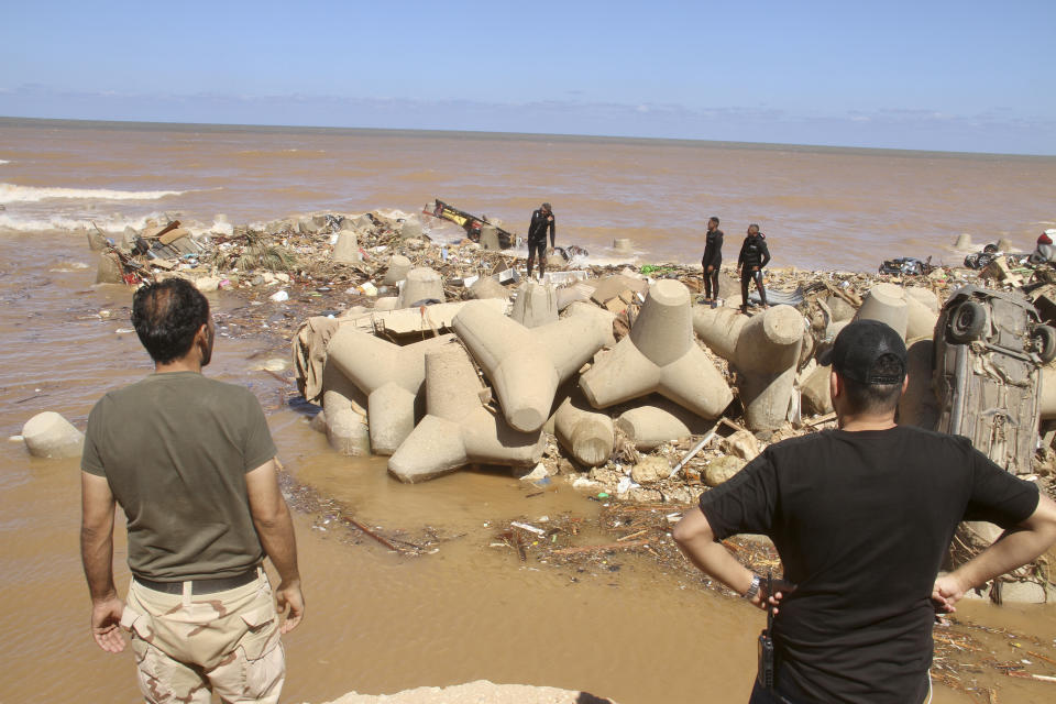 People look for survivors in Derna, Libya, Wednesday, Sept.13, 2023. Search teams are combing streets, wrecked buildings, and even the sea to look for bodies in Derna, where the collapse of two dams unleashed a massive flash flood that killed thousands of people. (AP Photo/Yousef Murad)