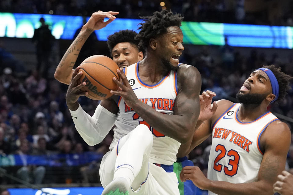 New York Knicks forward Julius Randle (30) grabs a rebound in front of Mitchell Robinson (23) and Dallas Mavericks forward Christian Wood during the first half of an NBA basketball game in Dallas, Tuesday, Dec. 27, 2022. (AP Photo/LM Otero)