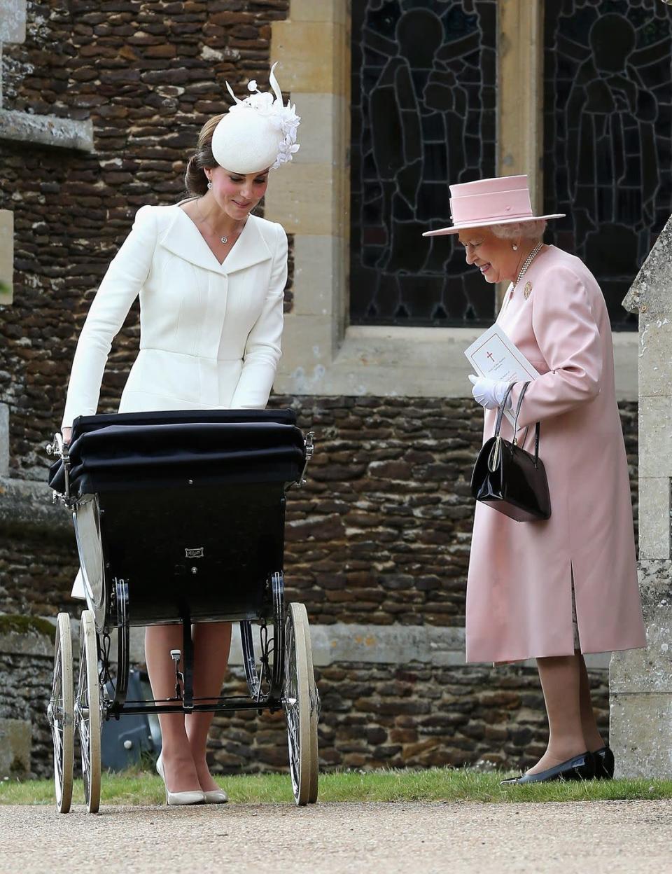 <p>The Queen smiles proudly at her great-granddaughter, Princess Charlotte with her mother, the Princess of Wales, after the christening. </p>