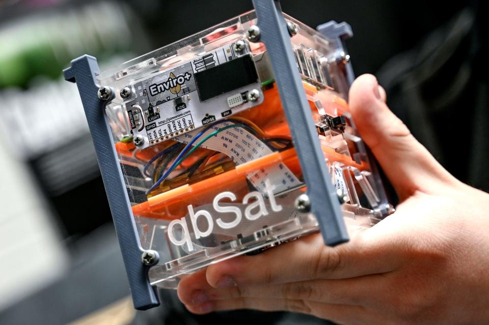 Senior Jack Hammerberg holds a satellite during robotics class on Tuesday, Feb. 7, 2023, at Stockbridge High School. Hammerberg has worked on a similar satellite that will travel to near outer space when it's launched from an East Coast launch site this year.