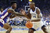 Kentucky's Oscar Tshiebwe (34) drives s Kansas' K.J. Adams Jr. defends during the first half of an NCAA college basketball game in Lexington, Ky., Saturday, Jan. 28, 2023. (AP Photo/James Crisp)