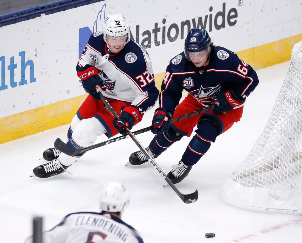 Columbus Blue Jackets defenseman Jake Christiansen (32) and forward Trey Fix-Wolansky (64) fight for a puck behind the net during the second period of a training camp scrimmage at Nationwide Arena in Columbus on Wednesday, Jan. 6, 2021. 