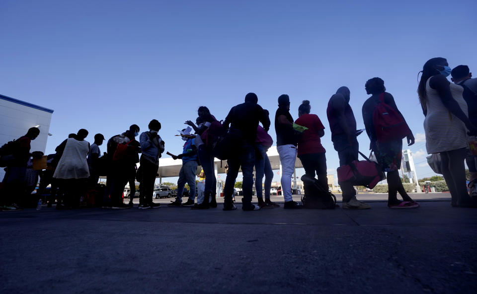 Migrants, mostly from Haiti, wait for a bus after they were processed and released after spending time at a makeshift camp near the International Bridge, Sunday, Sept. 19, 2021, in Del Rio, Texas. President Joe Biden's administration is nearing a final plan to expel many of the thousands of Haitian migrants who have suddenly crossed into a Texas border city from Mexico and to fly them back to their Caribbean homeland. (AP Photo/Eric Gay)