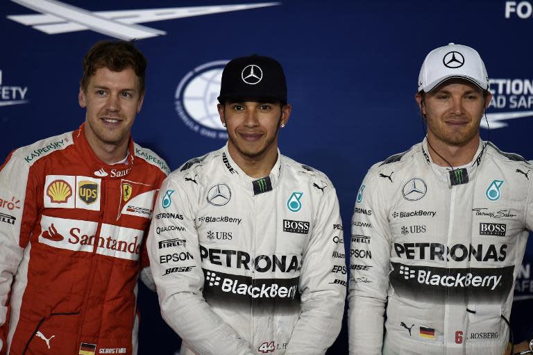 Mercedes AMG Petronas British driver Lewis Hamilton (C), Scuderia Ferrari German driver Sebastian Vettel (L) and Mercedes AMG Petronas German driver Nico Rosberg (R) pose for a photo on the podium at the Sakhir circuit in Bahrain on April 18, 2015