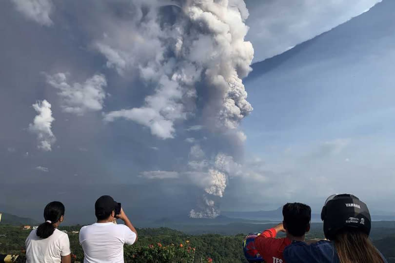 菲律賓的塔爾火山今日下午噴發，吸引附近島嶼民眾拍照。（圖／翻攝自AFP ）  