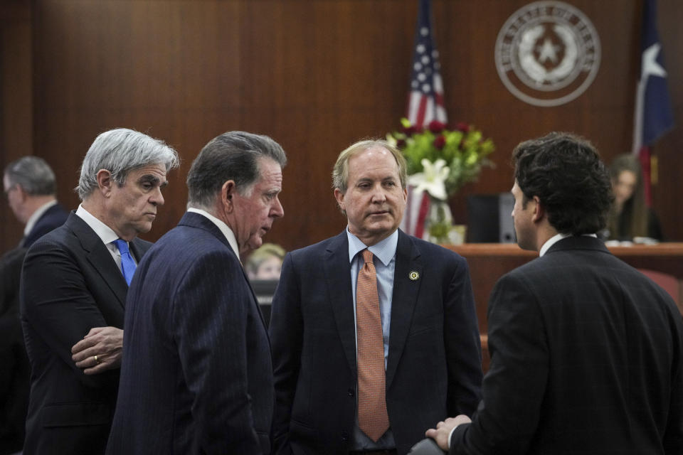 Texas Attorney General Ken Paxton, second from right, talks with his defense attorneys Philip Hilder, from left, Dan Cogdell, and Anthony Osso, Jr., after Paxton appeared in the 185th District Court for a hearing in his securities fraud case, Friday, Feb. 16, 2024, at the Harris County criminal courthouse in Houston. A judge on Friday rejected Paxton’s attempts to throw out felony securities fraud charges that have shadowed the Republican for nearly a decade. (Jon Shapley/Houston Chronicle via AP)