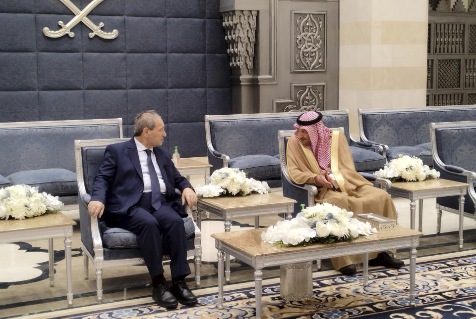 In this photo released by the Syrian official news agency SANA, Saudi Deputy Foreign Minister Waleed Al-Khuraiji, right, meets with Syrian Foreign Minister Faisal Mekdad, upon his arrival at King Abdulaziz International Airport, in Jeddah, Saudi Arabia, Wednesday, April 12, 2023. Syria will reopen its embassy in Tunisia, state media reported Wednesday, as Syria's top diplomat visited Saudi Arabia seeking to restore ties that have been severed for more than a decade. (SANA via AP)