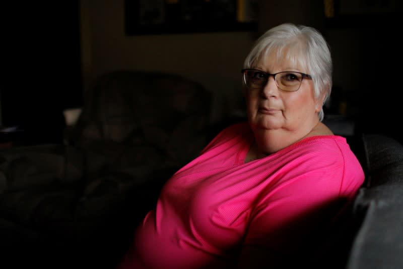 Debbie de los Angeles, whose mother died from coronavirus disease, poses for a portrait at her home in Monroe