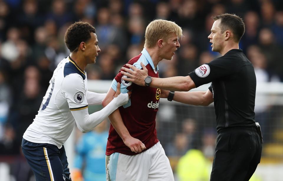 <p>Tottenham’s Dele Alli holds on to Burnley’s Ben Mee as referee Stuart Attwell speaks to him </p>