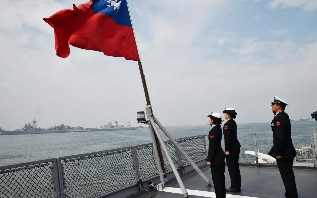 Taiwanese sailors salute the island's flag - Mandy Cheng/AFP