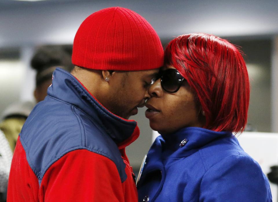 Lesley McSpadden (R), the mother of slain teenager Michael Brown, is greeted by her husband Louis Head as she returns from a hearing of the Committee against Torture at the United Nations in Geneva, at the airport in St. Louis, Missouri, November 14, 2014. The Missouri grand jury decision on whether to indict a white Missouri police officer, Darren Wilson, for fatally shooting the unarmed black teenager, Brown, is nearing, a lawyer for the family said on Thursday, calling for calm in a situation that has put police and residents on edge. REUTERS/Jim Young (UNITED STATES - Tags: CRIME LAW CIVIL UNREST POLITICS)