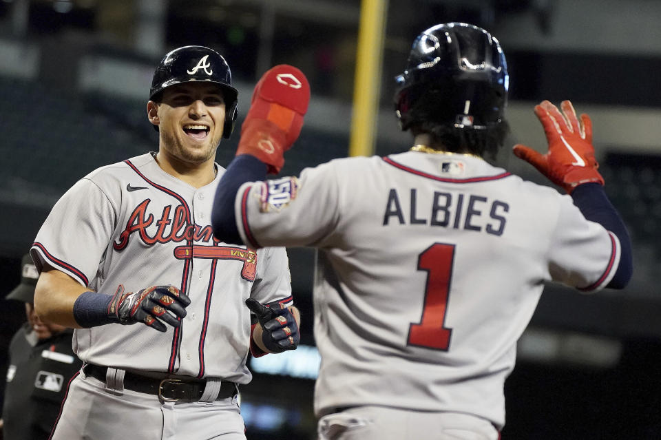 CORRECTS TO AUSTIN RILEY NOT FREDDIE FREEMAN - Atlanta Braves' Austin Riley, left, laughs as Ozzie Albies (1) waits to congratulate him after he hit a two-run home run against the Arizona Diamondbacks during the third inning of a baseball game Thursday, Sept 23, 2021, in Phoenix. (AP Photo/Darryl Webb)