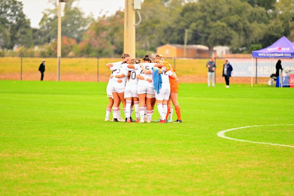 William Carey women's soccer players huddle during an NAIA quarterfinals game against Aquinas College (Mich.) on Nov. 30, 2023.