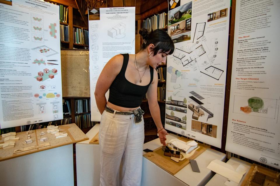 Ella Nadeau points out features on the model accessory dwelling unit she designed with her team as part of a collaboration between the Rhode Island School of Design and AARP on display at the State House library on Jan. 25. Her team won the design contest.