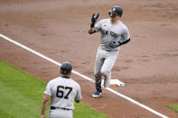 New York Yankees' Austin Wells, top, celebrates his home run as he rounds the bases by third base coach Luis Rojas (67) during the third inning of a baseball game against the Baltimore Orioles, Tuesday, April 30, 2024, in Baltimore. (AP Photo/Nick Wass)