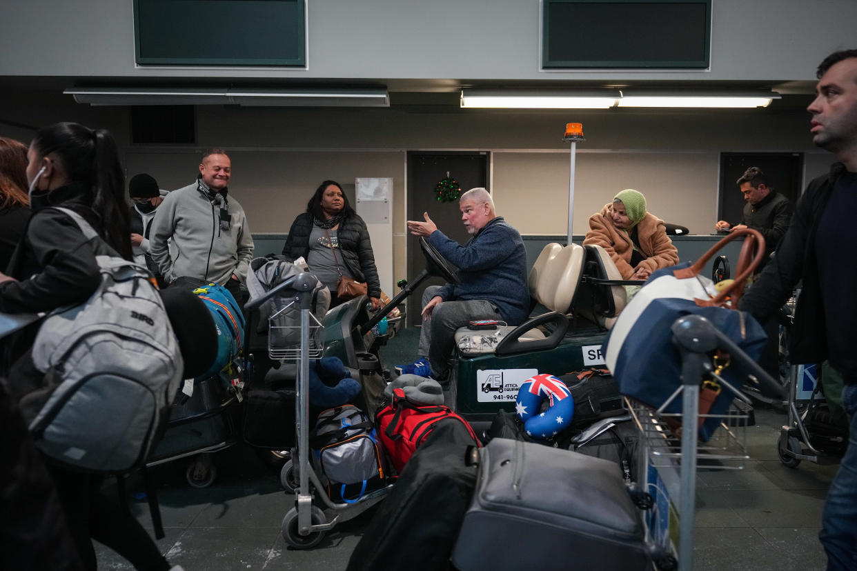 People sit on a golf cart at Vancouver International Airport after a snowstorm crippled operations leading to cancellations and major delays, in Richmond, B.C., on Tuesday, December 20, 2022. THE CANADIAN PRESS/Darryl Dyck