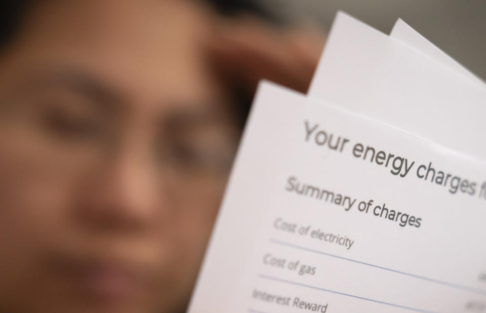 A person holding an energy bill as insolvency rises