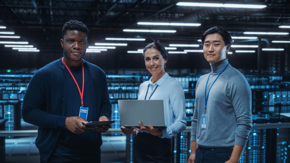 Three IT professionals working in a data center.