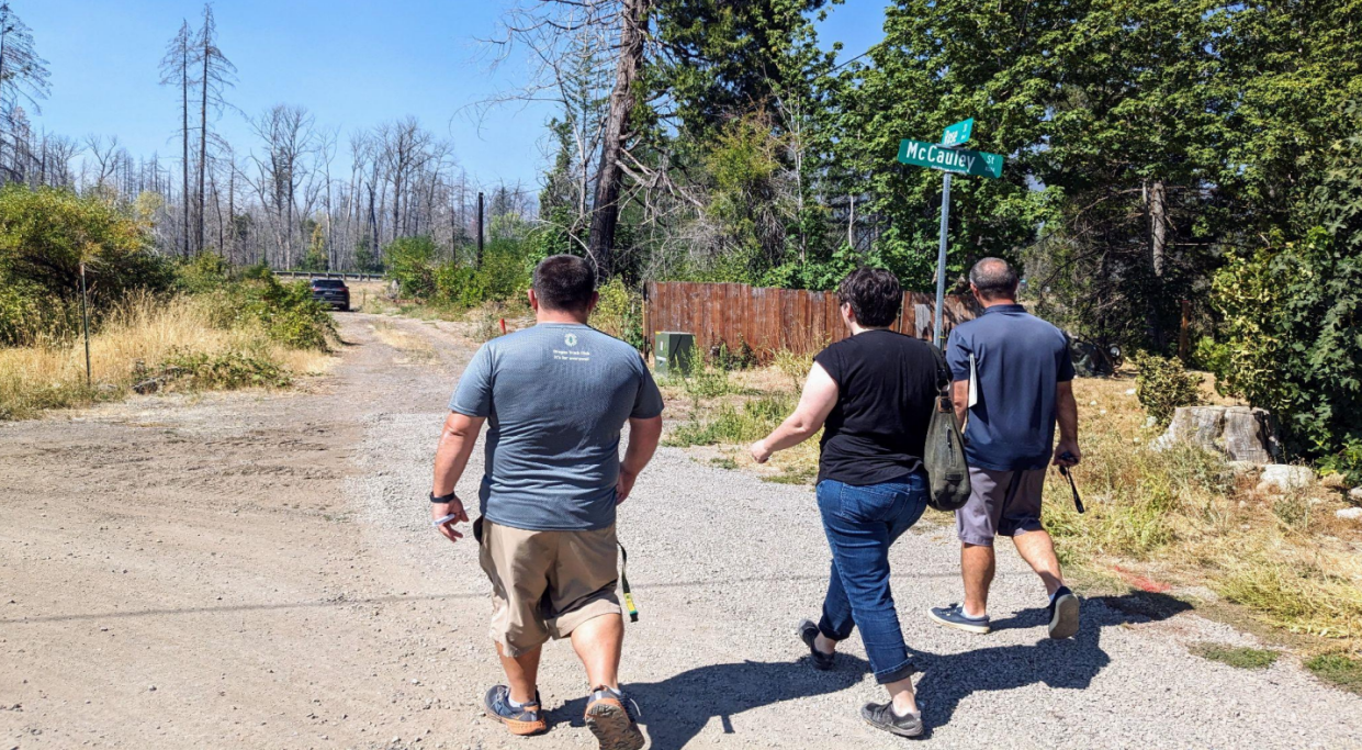 Lane Tompkins, chair of McKenzie Community Land Trust (left), Emily Reiman, CEO of DevNW, and Josh Shafer, senior project manager at DevNW, walk toward the lot where the two nonprofits will build six affordable homes in Blue River.
