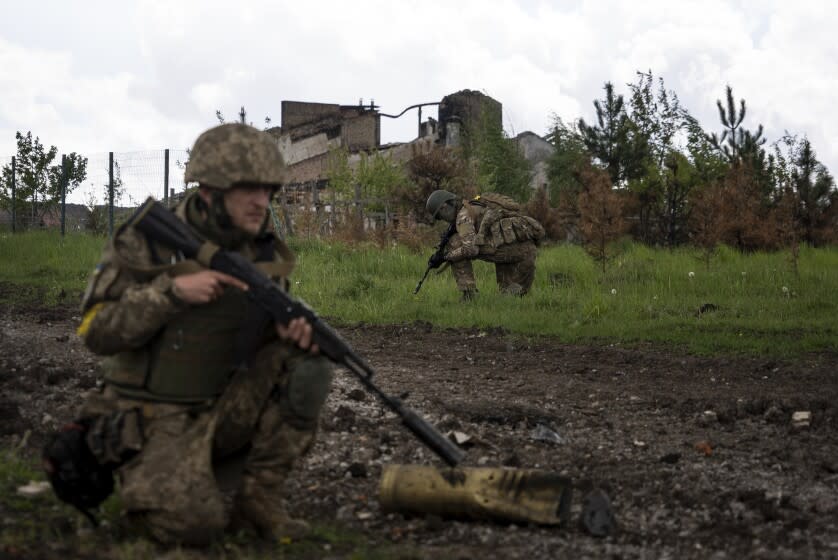 Ukrainian servicemen squat during a patrol in a recently retaken village, north of Kharkiv, east Ukraine, Sunday, May 15, 2022. (AP Photo/Mstyslav Chernov)