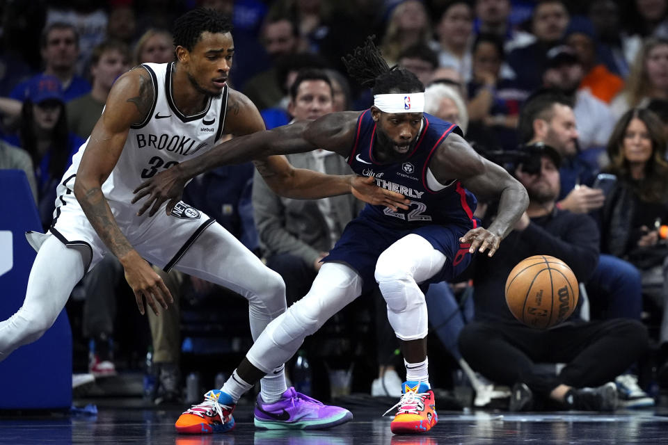 Philadelphia 76ers' Patrick Beverley, right, and Brooklyn Nets' Nic Claxton chase a loose ball during the second half of an NBA basketball game, Saturday, Feb. 3, 2024, in Philadelphia. (AP Photo/Matt Slocum)